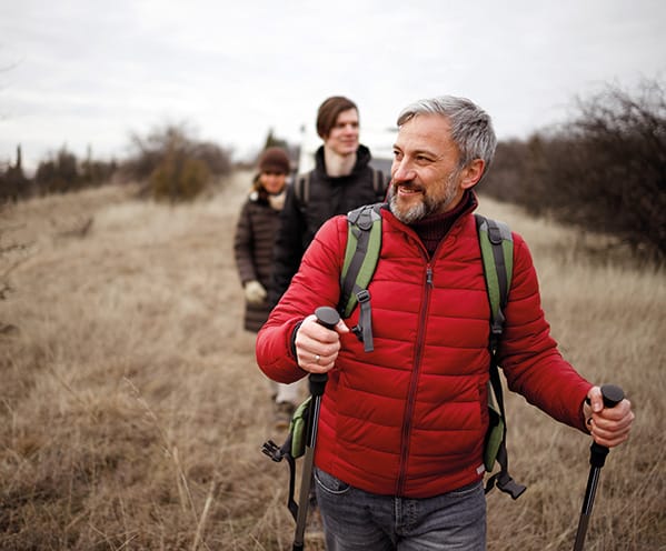 Aantal mensen die in een rij door de duinen lopen